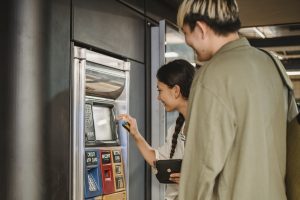 Content couple using ticket machine in underground