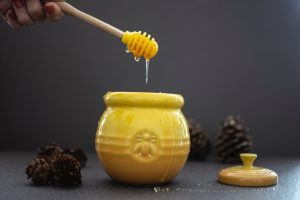 opened yellow ceramic jar beside pine cones