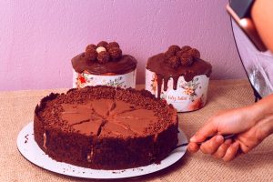 a person holding a knife over a chocolate cake